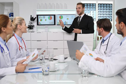 Business man showing graphs to doctors