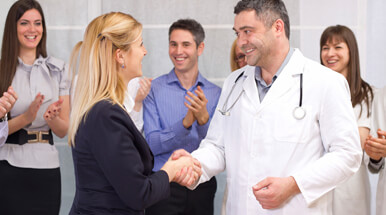 男性穿白大褂的医生和一个金发女握手的黑色西装。