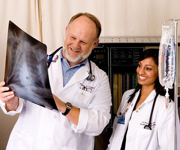 男性和女性穿着白大褂的医生,检查x射线。